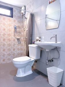 a bathroom with a white toilet and a sink at At The Beach Apartments in Panwa Beach