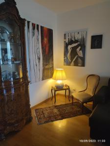 a living room with a table and a chair and a lamp at Tuscan Gallery House in Grosseto