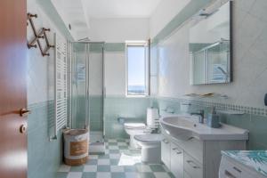 uma casa de banho com um lavatório, um WC e uma janela. em A Casa Mia em Floridia