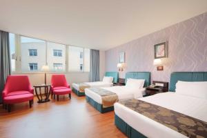 順德的住宿－佛山冠新酒店，酒店客房带两张床和一张桌子以及椅子。