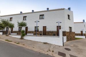 una casa blanca con una valla delante en Apartamentos Rurales la Campiña en Casiñas Bajas