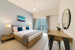 a bedroom with a bed and a desk and a mirror at Capital Living On Reem - The Arc Towers & The Gate in Abu Dhabi