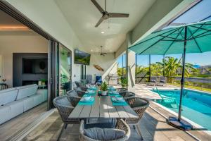 una sala da pranzo con tavolo, sedie e piscina di Villa Mangifera with Salt Water Pool & Spa, EV-Loading a Cape Coral