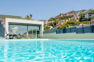 a swimming pool with a view of a building at Luxurious Villa Marly I to two minutes the beach in Castelldefels