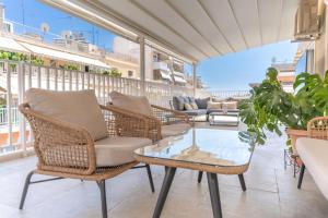 a patio with chairs and a table on a balcony at Sunny & Luxurious Penthouse with Terrace in Athens