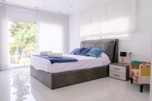 Un dormitorio con una cama grande y una ventana en Luxurious Villa Marly I to two minutes the beach, en Castelldefels