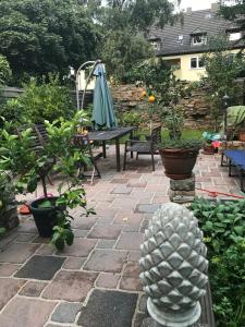 a patio with a table and an umbrella and plants at zentral, Mini Suite zwei Räumen, Parks, Messe in Düsseldorf