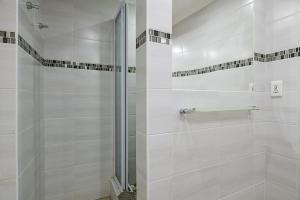 La salle de bains est pourvue d'une douche blanche avec une porte en verre. dans l'établissement Country Rose, à Hluhluwe