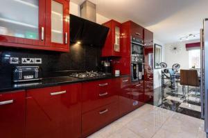 a kitchen with red cabinets and a counter top at Impeccable 3-Bed House in Manchester in Manchester