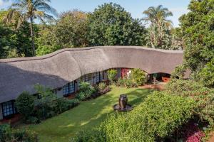 a house with a roof with a garden at Country Rose in Hluhluwe