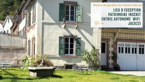 una casa con persianas verdes y un edificio con patio en Gîte Verrière Du Château BURRUS, en Sainte-Croix-aux-Mines