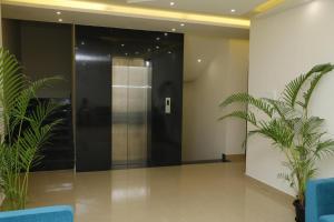 un ascenseur dans un immeuble avec deux plantes dans l'établissement SENTHUR INN VELLORE Sathuvachari, à Vellore