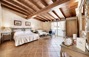 a large bedroom with a bed and a table at COLONNA RESORT, a Colonna Luxury Beach Hotel, Porto Cervo in Porto Cervo