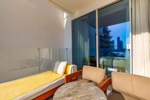 Five Palm Hotel and Residence - Platinium Dubai في دبي: غرفة معيشة بها أريكة وكراسي ونافذة كبيرة