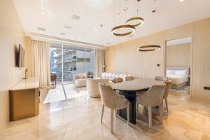 Five Palm Hotel and Residence - Platinium Dubai في دبي: غرفة طعام مع طاولة وكراسي وغرفة معيشة