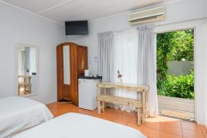 a bedroom with a bed and a sliding glass door at Hlulala Guest House in Hluhluwe