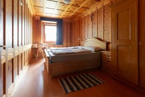a bedroom with a bed in a wooden cabin at Appartamento Scialket in Livigno