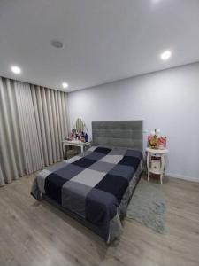 a bedroom with a large bed with two tables at Valadares House in Corroios