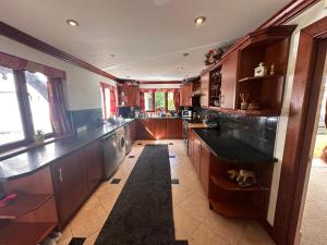 una grande cucina con armadi in legno e piano di lavoro di Reemdale Manor - Fulwood Row Preston PR25RW a Grimsargh