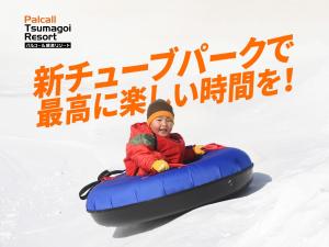 een persoon rijdt op een buis in de sneeuw bij Palcall Tsumagoi Resort Ski & Hotel in Tsumagoi