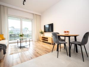 OAK TREE Apartment في دونبروفا جورنيتشا: غرفة معيشة مع طاولة وكراسي وتلفزيون