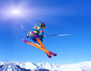 un homme volant à travers l'air en faisant du ski dans l'établissement Le Balcon des Ecrins, à Réallon