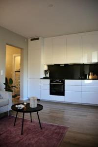 a living room with a table and a kitchen at Stylish 3-room apartment with balcony and free parking in Oslo