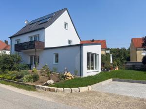 een wit huis met zonnepanelen op het dak bij Ferienwohnung Am Sulzpark in Beilngries