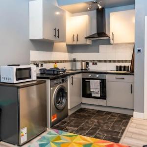 a kitchen with a washing machine and a microwave at Eastville Superb Dwelling, sleeps up to 4 guests in Bristol