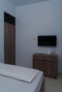 a bedroom with a bed and a flat screen tv at OYO Life 92878 Kost Padma Syariah in Kandang-besar