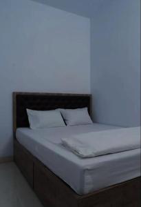 a bed in a room with a light on it at OYO Life 92878 Kost Padma Syariah in Kandang-besar