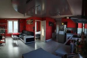 Il comprend une cuisine et un salon avec des murs rouges. dans l'établissement T2-42m2-Climatisation, lumière tamisée-garage, à Bourgoin-Jallieu