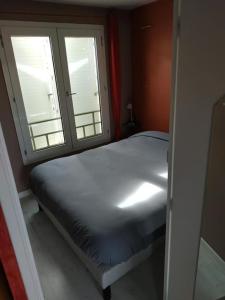 - une petite chambre avec un lit et 2 fenêtres dans l'établissement T2-42m2-Climatisation, lumière tamisée-garage, à Bourgoin-Jallieu