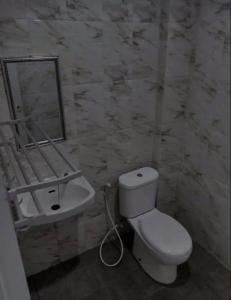 a bathroom with a white toilet and a sink at OYO Life 92878 Kost Padma Syariah in Kandang-besar
