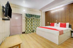 a bedroom with a bed and a flat screen tv at Hotel Shimla View in Jutogh