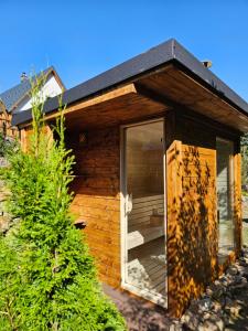 Cabaña de madera con una gran puerta de cristal en Resort Biela Skala - CHATA en Bystrá