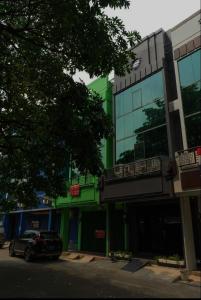 a car parked in front of a green building at OYO Life 92878 Kost Padma Syariah in Kandang-besar