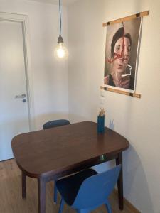 a dining room table with two blue chairs and a painting at Außergewöhnliches Apartment in bester Lage in Biberach an der Riß