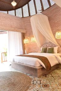 a bedroom with a bed with a mosquito net at Dusun The Villas 