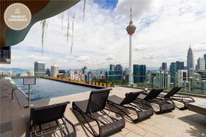 Un grupo de sillas en una azotea con vistas a la ciudad. en Ceylonz Suite KLCC, Travelet, en Kuala Lumpur