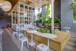 Ceylonz Suite KLCC, Travelet في كوالالمبور: مطعم بطاولات وكراسي في غرفة بها نباتات