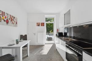 a white kitchen with a sink and a counter top at Infinity Stay: Ferienappartments Rheinstrasse in Wilhelmshaven