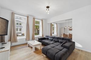 uma sala de estar com um sofá e uma mesa em Infinity Stay: Ferienappartments Rheinstrasse em Wilhelmshaven