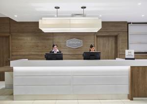 two women sitting at a reception desk with their laptops at Hampton by Hilton Oxford in Oxford