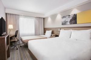 a hotel room with a bed and a television at Hampton by Hilton Oxford in Oxford