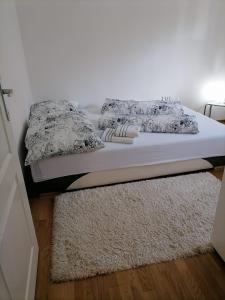 uma cama com duas almofadas e um tapete num quarto em Airport Apartment em Surčin