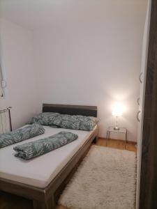 a bedroom with two beds and a lamp and a rug at Airport Apartment in Surčin