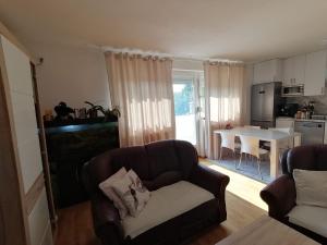 uma sala de estar com um sofá e uma cozinha com uma mesa em Airport Apartment em Surčin