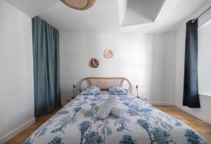 a bedroom with a bed with a blue and white blanket at Le Wilson - Appartement design - Hyper centre in Vichy