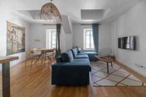 - un salon avec un canapé bleu et une table dans l'établissement Le Wilson - Appartement design - Hyper centre, à Vichy